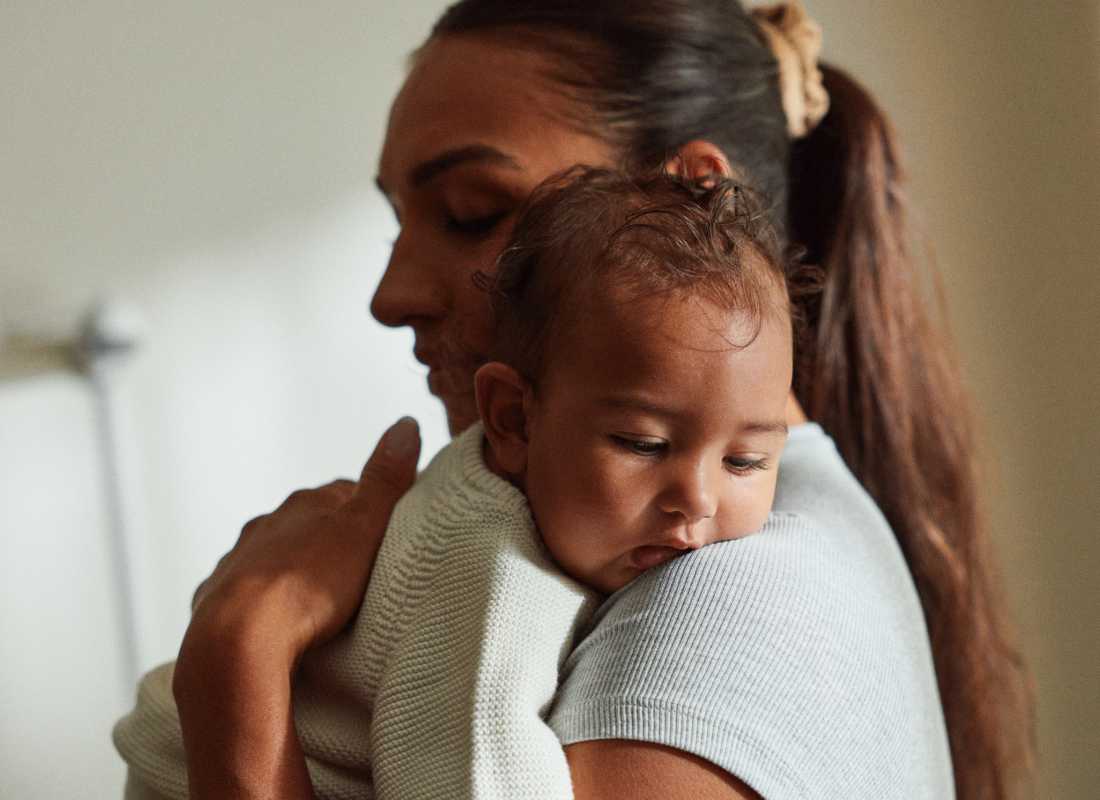 Mum holds a sleepy baby