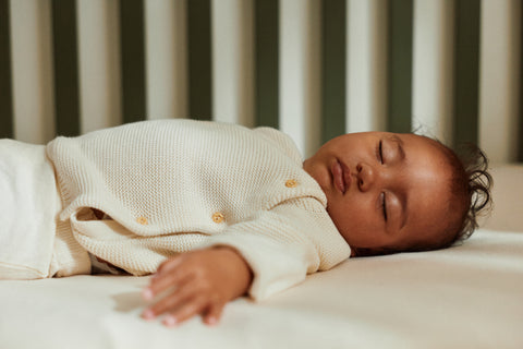 Parent settling baby in a clear sleep space